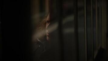 A moody and reflective man is gazing through a window, lost in contemplation and deep in thought video