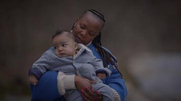 Mother and baby showing affection outdoors in winter, surrounded by trees, warm and protective video