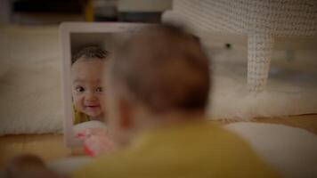 An innocent baby happily explores, gazing at their reflection with curiosity and delight video