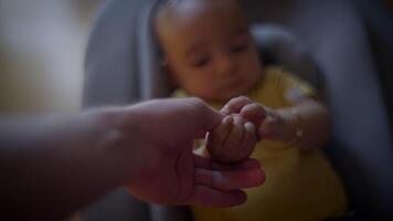 A touching scene depicted through a parent gently holding the babys hand in a closeup view video
