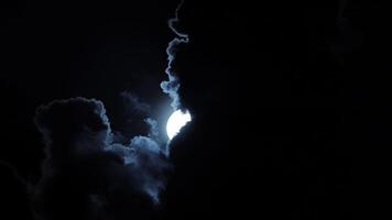 A Full Moon, partially obscured by dramatic clouds, creates a mysterious and celestial atmosphere video