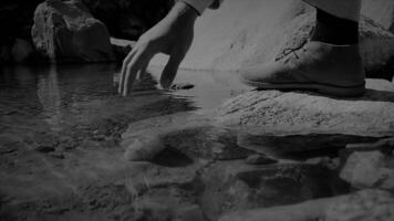 A closeup perspective of a shoe resting beside a peaceful stream in a tranquil natural setting video