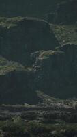 A mountain range with rocks and grass in the foreground video