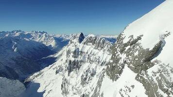 Snowcovered Alpine Mountain Range with stunning views for hikers under clear blue sky video