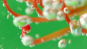 Underwater view of blooming flower into the water with air bubbles. Stock footage. Underwater close up view of yellow and orange flower floating into the water. video