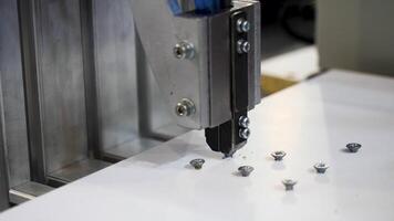 Machine twisting nails. Media. Close-up of automated machine twisting nails. Production machine that screws nails and bolts on boards video