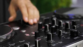 Close-up of man playing on dj console. Media. Man turns buttons on music console. DJ plays new music console at disco video