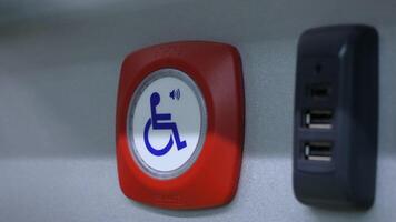 Close-up button for disabled people. Media. Help button for people with disabilities. Button to help disabled people in public transport video