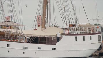 Beautiful moored white large ship. Action. New frigate on a cloudy sky background, concept of holidays and journey. video