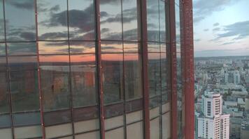 A long glass office.Stock footage.The view from the drone is of a huge office with glass windows and large buildings around and you can see the cloudy sky. video