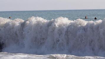 A big wave breaks on the seashore. CREATIVE. Powerful white wave crest in windy sunny weather on the beach video