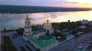Summer sunny landscape from a drone.Clip.A beautiful large cathedral located in the city next to the river and next to various residential buildings on the background of a beautiful patterned sky. video