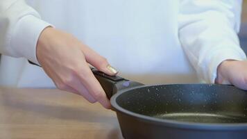 The woman removed the handle from the pan. ACTION. The cook holds a frying pan handle in his hand. Black frying pan in the hands of the cook video