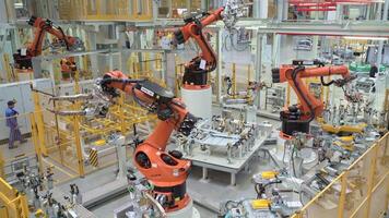 Russia, Moscow - May 7, 2022. Automated plant with robotics and workers. Scene. Lot of robotic machines create car parts in modern factory. Modern robotic equipment at factory with workers video