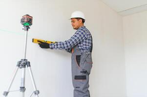 An Indian worker works in an empty apartment. A man in a uniform makes repairs inside the building photo