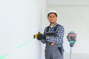 An Indian worker works in an empty apartment. A man in a uniform makes repairs inside the building photo