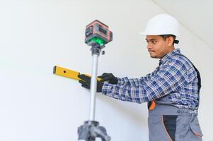 An Indian worker works in an empty apartment. A man in a uniform makes repairs inside the building photo