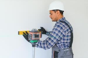 An Indian worker works in an empty apartment. A man in a uniform makes repairs inside the building photo