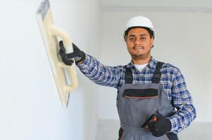 An Indian worker works in an empty apartment. A man in a uniform makes repairs inside the building photo