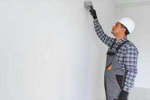 An Indian worker works in an empty apartment. A man in a uniform makes repairs inside the building photo