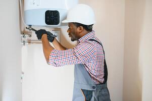 Professional engineer installing a natural gas boiler at home, he is checking the pipes photo