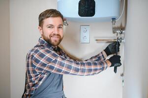 Professional engineer installing a natural gas boiler at home, he is checking the pipes photo