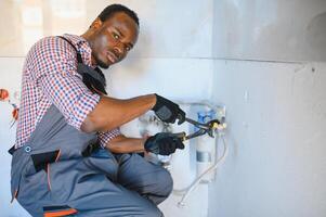 African American Plumber installs a water filter. water filter. photo