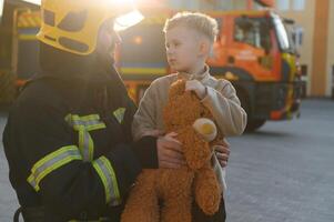 Firefighter holding child boy to save him in fire and smoke,Firemen rescue the boys from fire photo