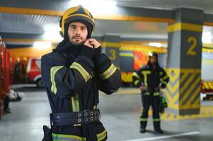 A firefighter puts on a fire uniform at the fire department photo