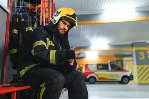 fireman sitting on bench at fire station photo