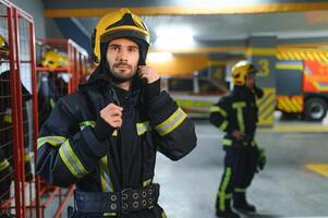 A firefighter puts on a fire uniform at the fire department photo