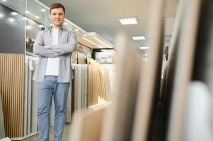 Male architect or interior designer choosing ceramic texture sample from swatch board in design studio photo