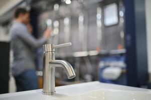 Modern kitchen and bathroom water faucets in the store photo