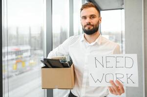 Man by dismissal. Guy lost job. Fired manager in company. Dismissal box in hands of employee. photo