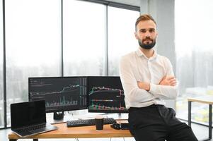 Financial Analysts and Day Traders Working on a Computers with Multi-Monitor Workstations with Real-Time Stocks, Commodities and Exchange Market Charts photo