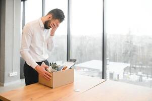 Man by dismissal. Guy lost job. Fired manager in company. Dismissal box in hands of employee. photo