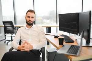 Crypto trader sits at his workplace in front of a monitor with charts. photo