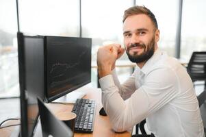 Financial Analysts and Day Traders Working on a Computers with Multi-Monitor Workstations with Real-Time Stocks, Commodities and Exchange Market Charts photo