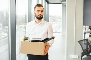 Man by dismissal. Guy lost job. Fired manager in company. Dismissal box in hands of employee. photo