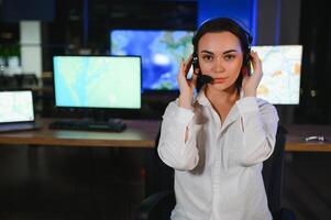 Friendly smiling woman call center operator with headset using computer at office photo