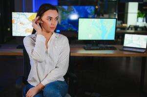 Friendly smiling woman call center operator with headset using computer at office photo