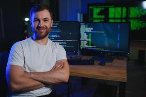 Male programmer working on desktop computer at white desk in office photo