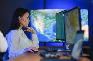 Friendly smiling woman call center operator with headset using computer at office photo