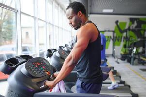 Man running on treadmill in gym photo