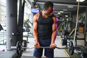 Athletic black guy making weightlifting or powerlifting at modern gym photo