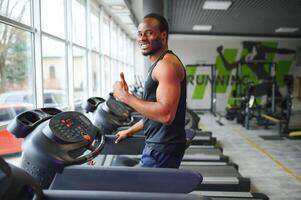 Man running on treadmill in gym photo