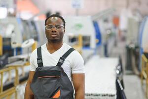 Industrial worker indoors in factory. Young technician with orange hard hat photo
