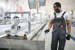 An African-American male worker in a plastic window frame factory photo