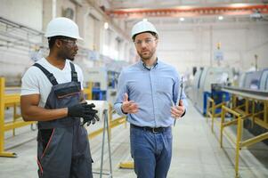Two workers at a factory for the production of plastic windows. Engineer and worker on the production line photo
