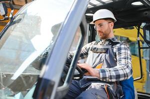 Man worker at forklift driver happy working in industry factory logistic ship photo